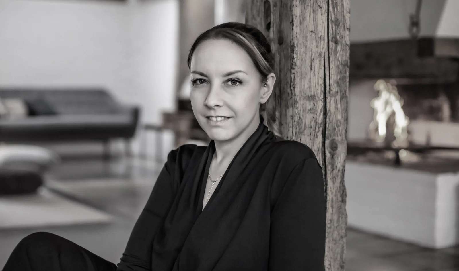 Jenny Wullich, communication designer from Munich, leaning against an old wooden beam